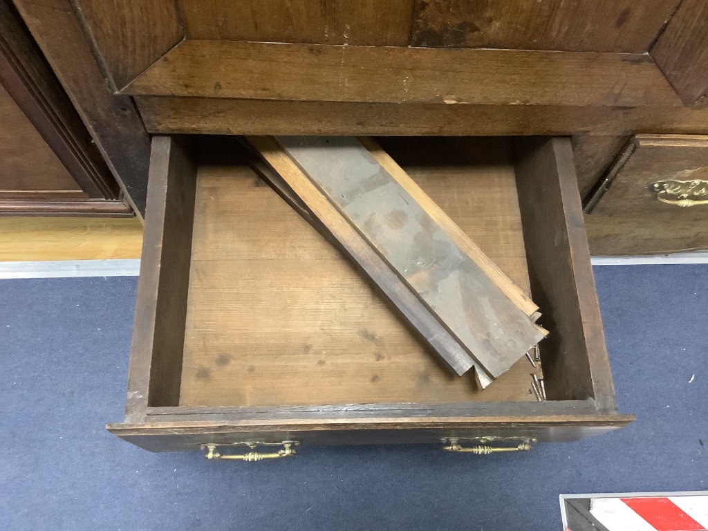 A large French knock-down armoire, with twin panelled doors over two long and one short central drawer, with polished brass mounts and handles, 18th century, width 160cm, depth 62cm, height 223cm